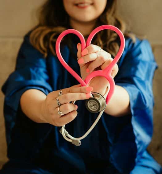 mulher médica fazendo um coração com o estetoscópio para ilustrar o post de o que é DMH
