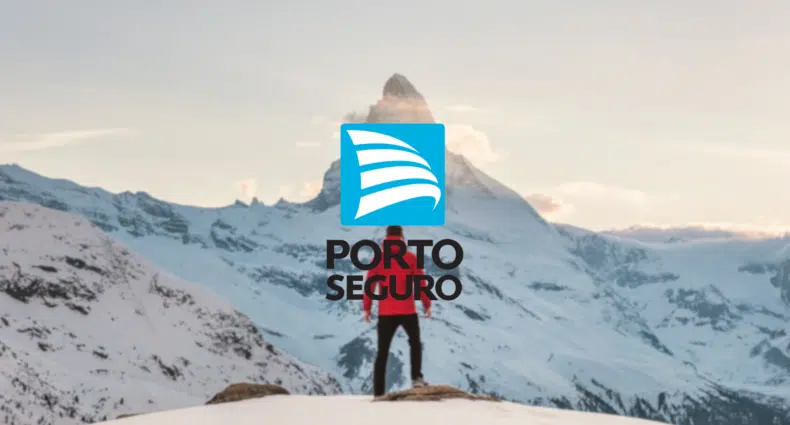 foto editada com uma pessoa de costas em frente a uma montanha totalmente nevada com o logo do Seguro viagem Porto Segura