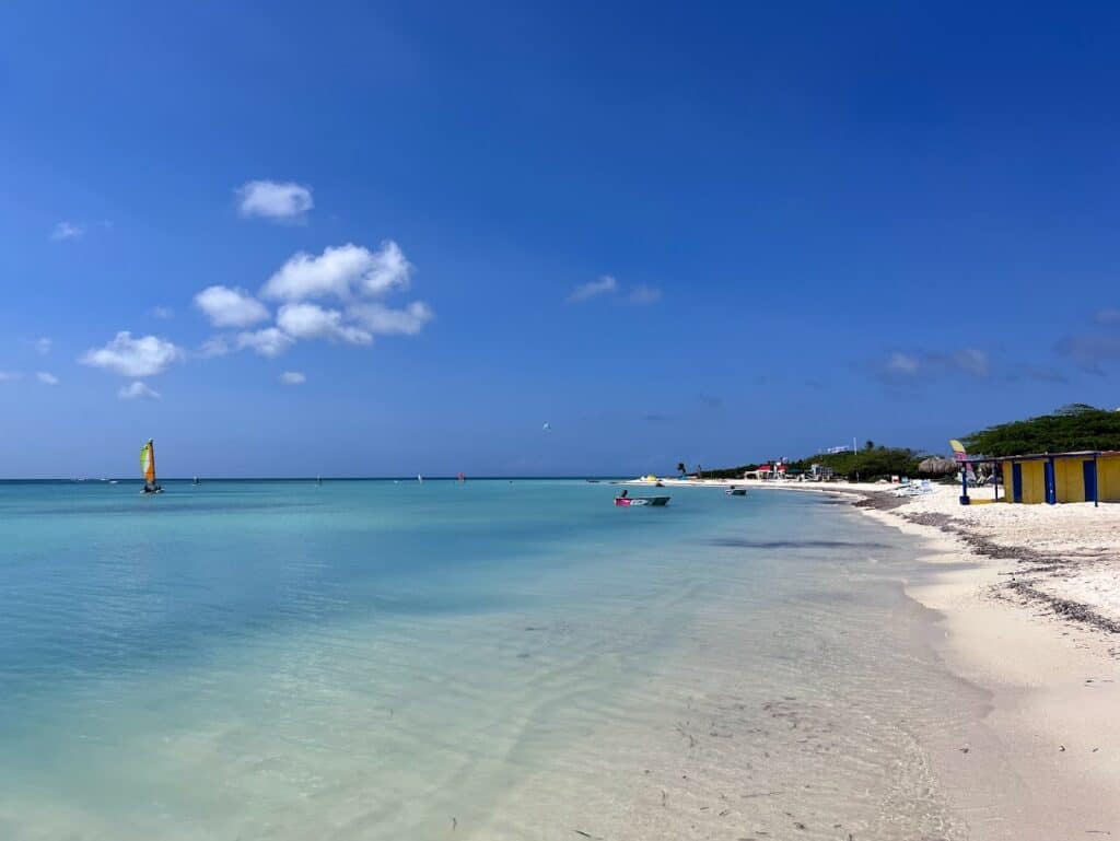 Mar da praia de Palm Beach. A água está azul e alguns barcos estão dentro dela. Do lado direito é possível ver uma parte da faixa de areia.