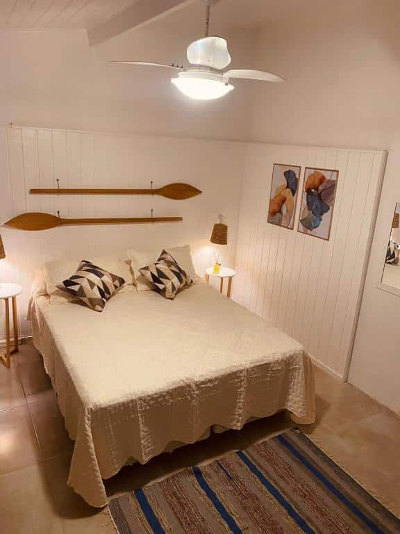 Quarto do Bosque Toque Toque – Pousada B&B com cama de casal no centro do quarto com uma cômoda em cada lado da cama. Representa hotéis em São Sebastião.