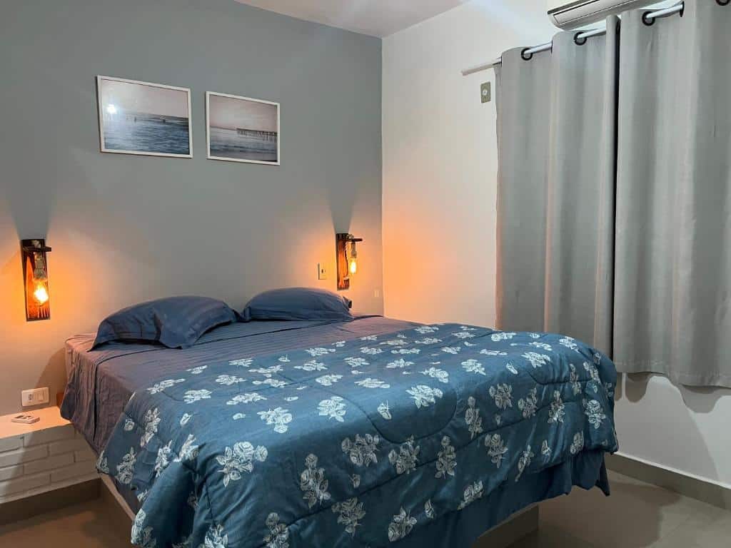 Quarto da Casa Vivá Guaeca com cama de casal do lado esquerdo da imagem no centro do ambiente. Representa airbnb na praia de Guaecá.