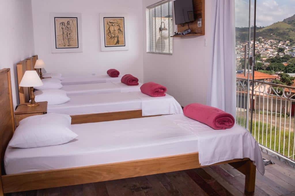 Quarto do Loft Sopro da Serra com quatro camas de solteiro do lado esquerdo da imagem. Representa airbnb em São João del Rei.
