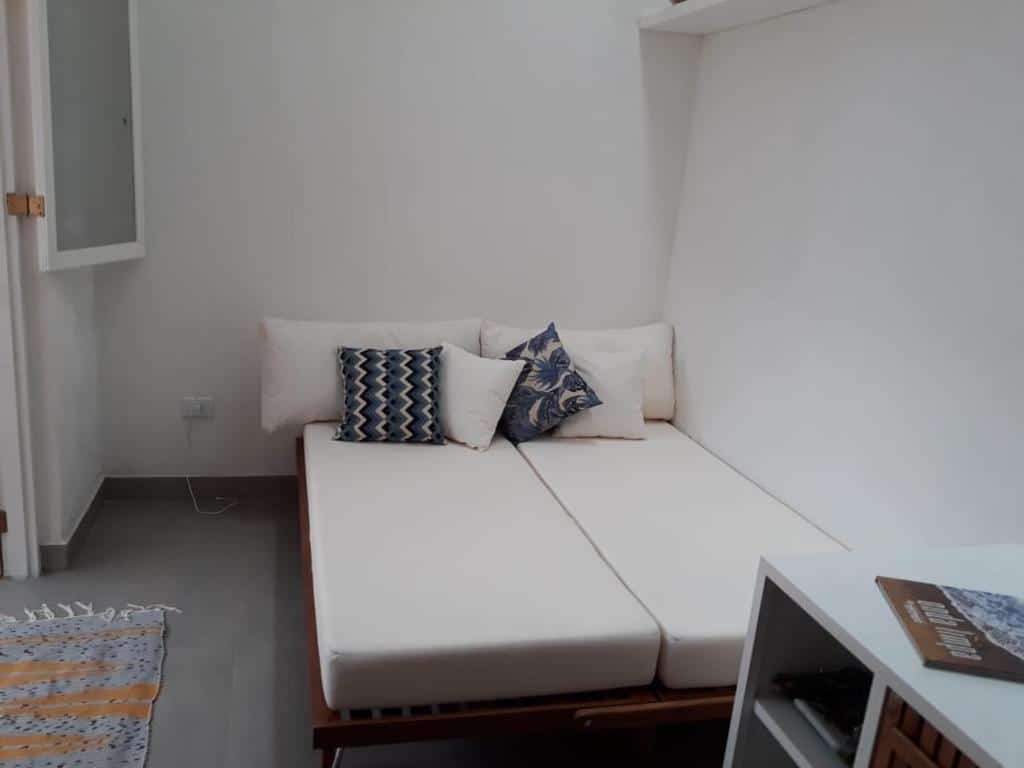 Quarto do lindo chalé em Boiçucanga Condomínio com cama do lado direito da imagem.