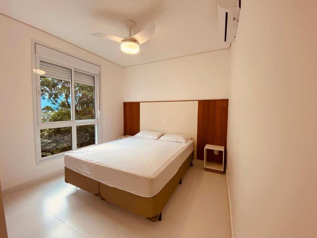 Quarto do Vista Mágica na Praia de Camburizinho com cama de casal no centro do ambiente em cada lado da cama uma cômoda. Representa airbnb em São Sebastião.