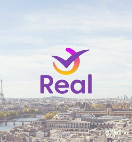 Cidade de Paris na França com uma vista aérea com destaque para a Torre Eiffel do lado esquerdo, com o logo da empresa Real Seguro Viagem em cima da imagem
