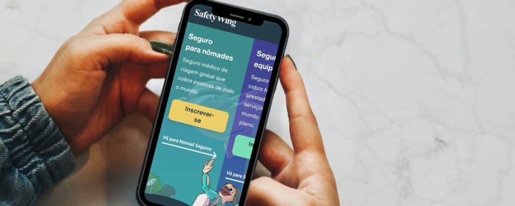Uma mulher usando um celular sob uma mesa branca, na tela está aberto o site da SafetyWing