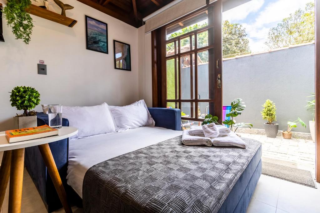 Sala de estar do Flats Una’s Corner – Novos – Ar Condicionado com sofá-cama do lado esquerdo da imagem e do lado esquerdo do sofá uma mesa com objetos em cima. Representa airbnb na praia do Engenho.