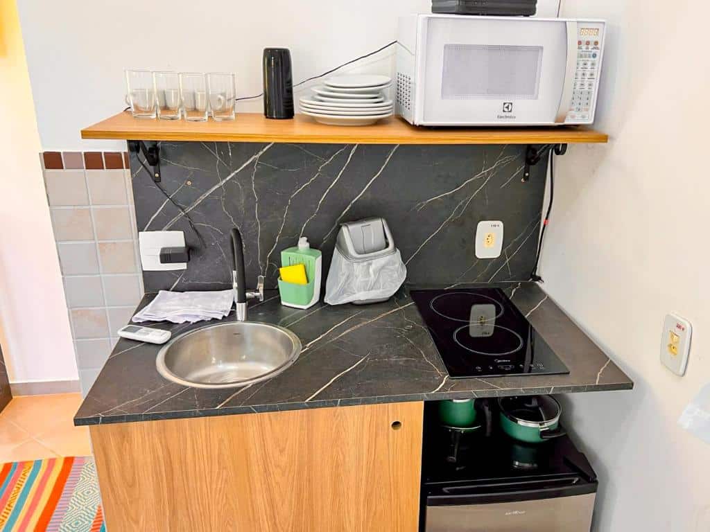 Close na pia das Suítes Naturaleza, onde há também um cooktop, um micro-ondas, um frigobar, panelas e utensílios.