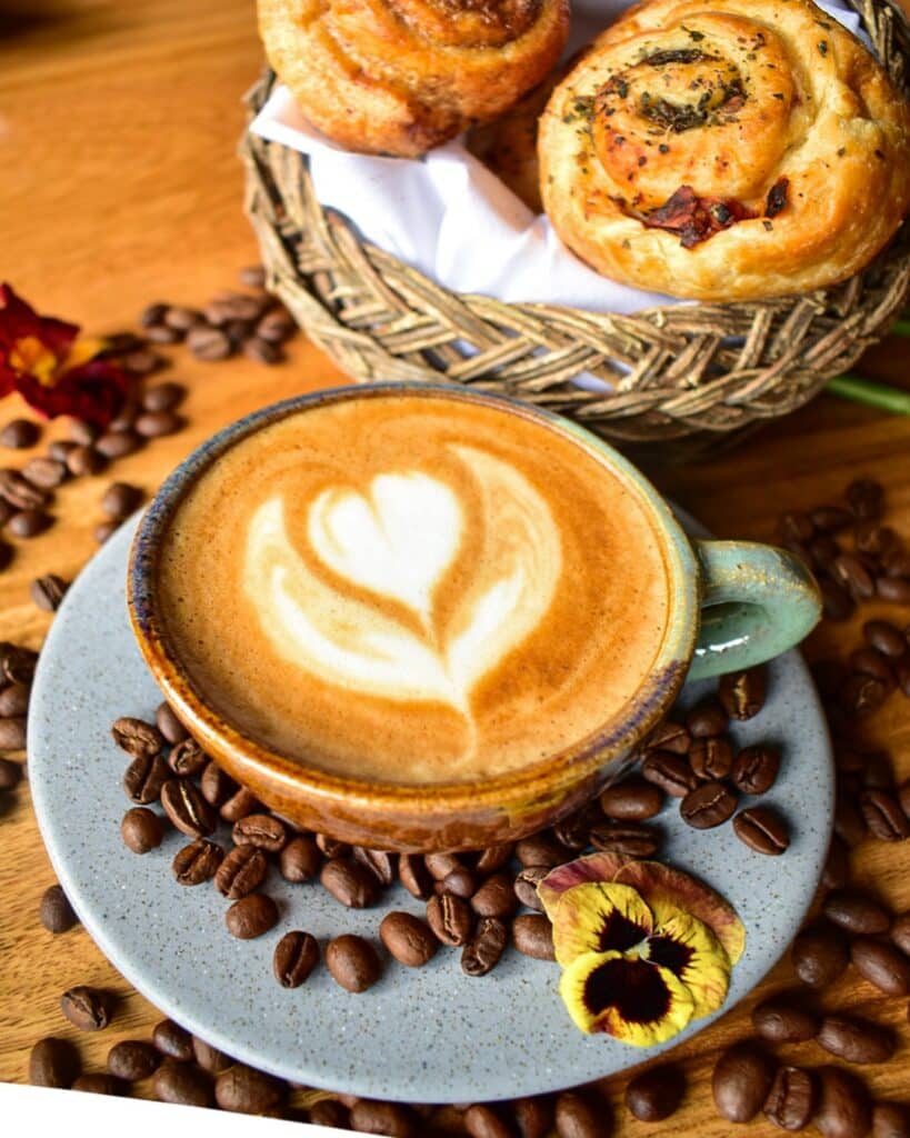 xícara de café e uma cestinha de pães doces do Organika Bakery & Coffee