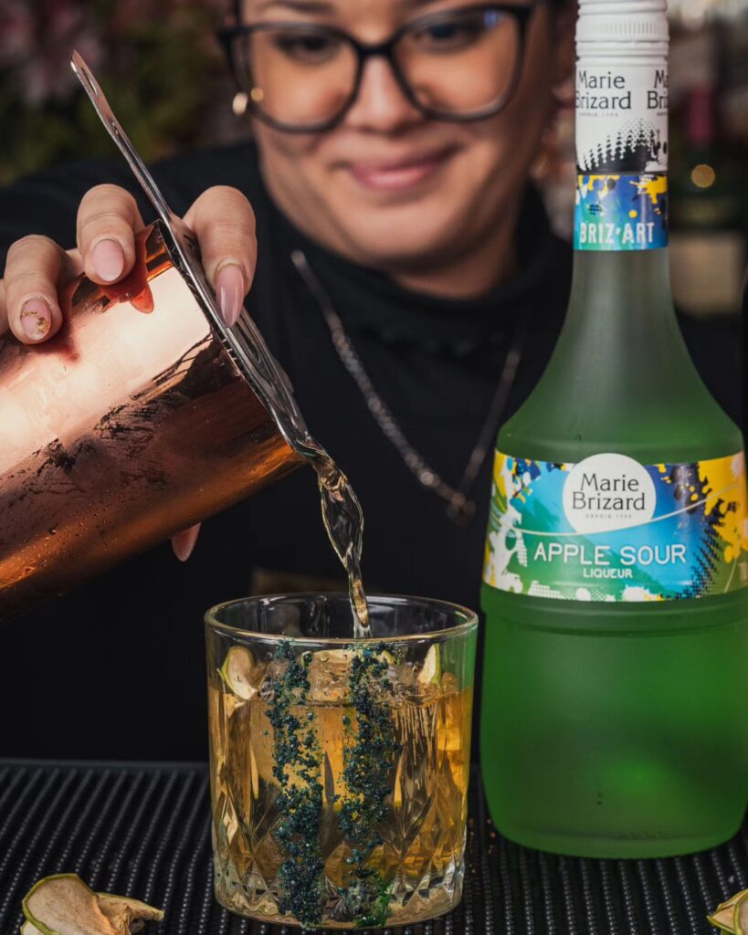 mulher despejando bebida dentro de um copo de vidro transparente no Molly's Irish Bar & Restaurant Cusco