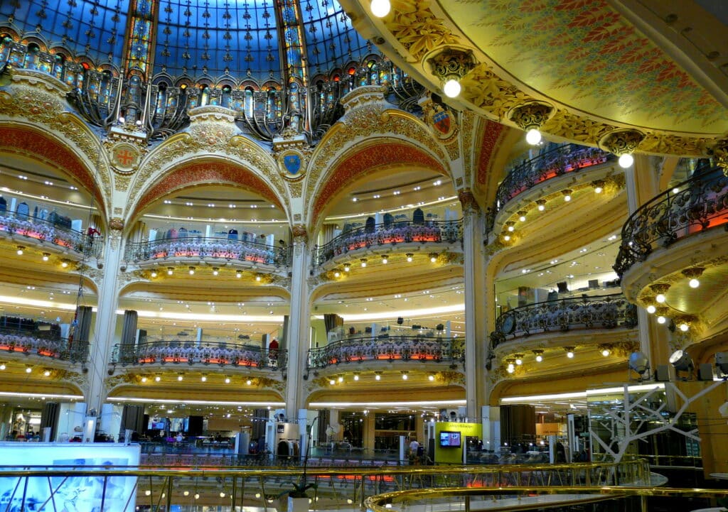 Interior da Galeria Lafayette, que é repleta de lojas em suas salas abobadadas e é uma das opções de o que fazer em Paris.