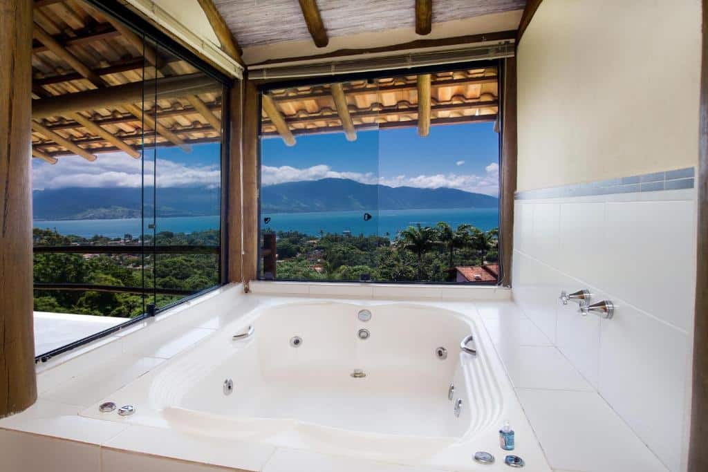 Hidromassagem dentro da suíte da Pousada Mariola. Está do lado de uma grande janela de vidro com vista para o mar.