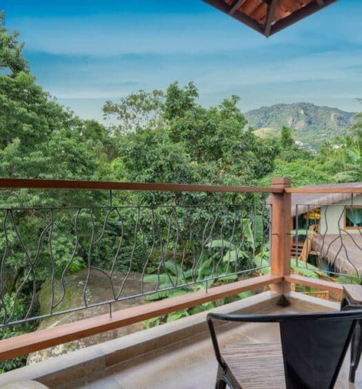 Foto tirada de uma varanda no Hotel Vila Kebaya. Mostra a vista para as montanhas e vegetação nativa de Ilhabela.
