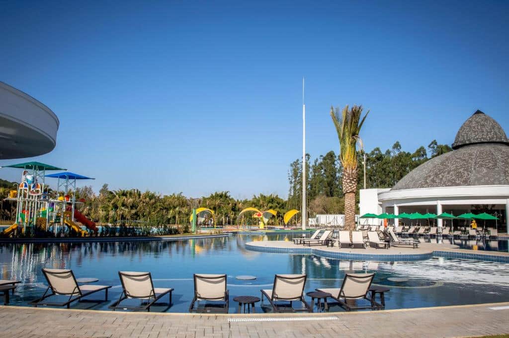 Área da piscina ao ar livre, cadeiras de tomar sol e brinquedos aquáticos do Jardins de Jurema Convention & Termas Resort.