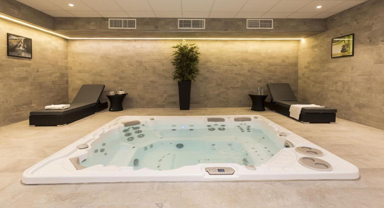 Banheira de hidromassagem no Odalys City Paris Montmartre com espreguiçadeiras nas duas laterais. Há também um vaso de plantas no centro do local, atrás da hidro.