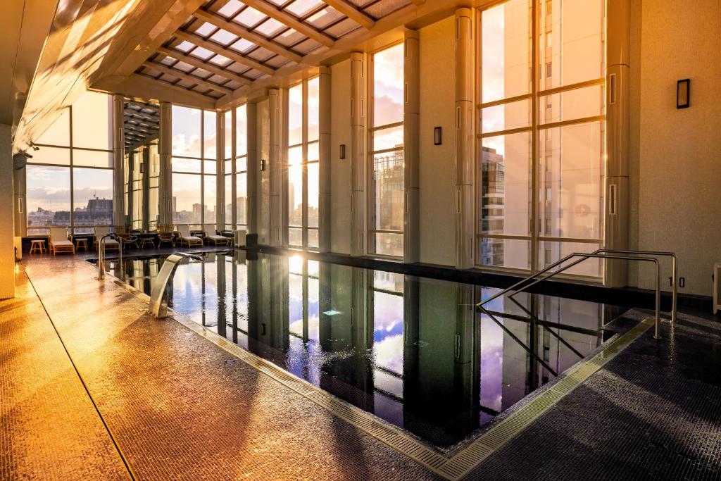 piscina interna do Alvear Icon Hotel, um hotel 5 estrelas em Buenos Aires ao por do sol em tons alaranjados com espreguiçadeiras ao redor 