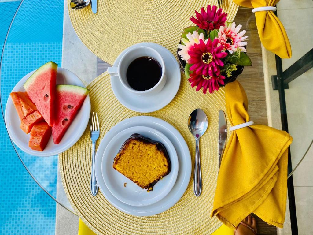 Vista de cima de uma mesa do café da manhã da Pousada Amaral Búzios. Do lado esquerdo a ponta da piscina.