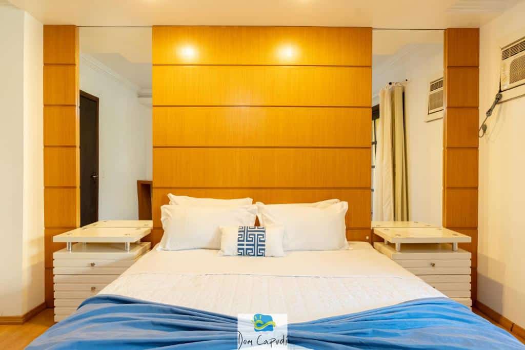 Quarto da Pousada Dom Capudi. Uma cama de casal no centro, de cala lado uma cômoda e um espelho. Foto para ilustrar post sobre pousadas pet friedly em Santa Catarina.