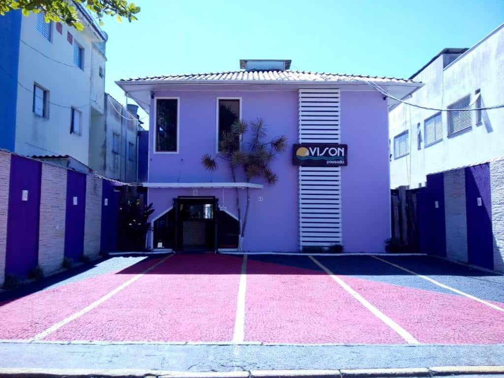 Propriedade da  Pousada Vison pintada em tom de lilás e com quatro vagas na frente para estacionar
