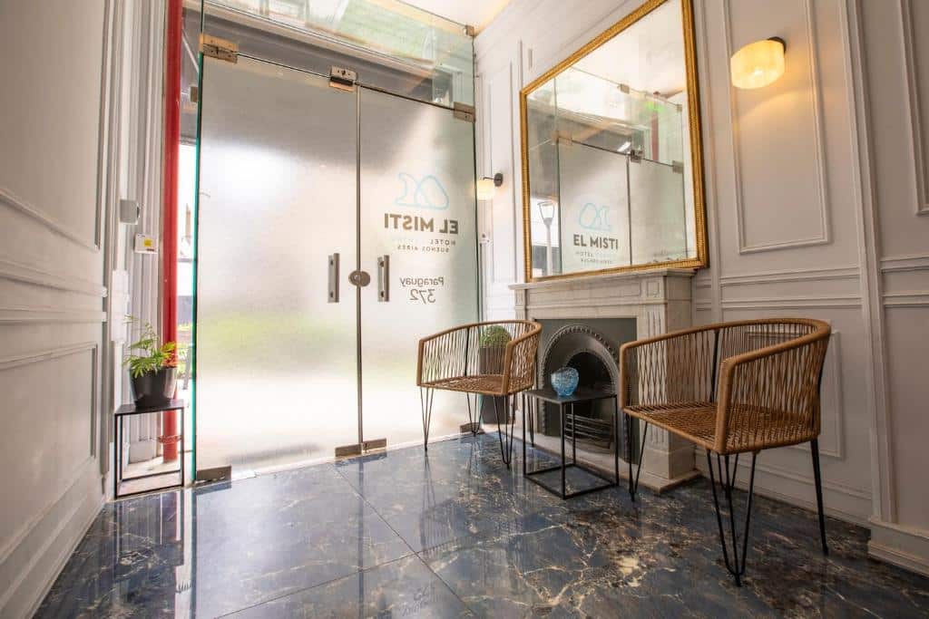 recepção do El Misti Hotel Buenos Aires Centro com cadeiras leves, espelho grande e portas de blindex 