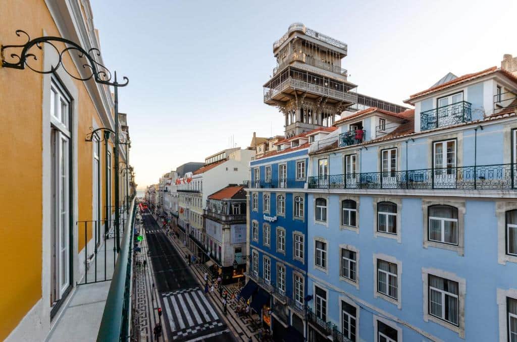 Visão da sacada do Rossio Plaza Hotel com vista para uma rua com prédios históricos e o Elevador de Santa Justa, para representar hotéis 3 estrelas em Lisboa
