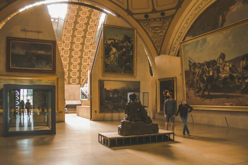 Um casal observa a estátua e os quadros pendurados no Museu d'Orsay, uma das opções de o que fazer em Paris.
