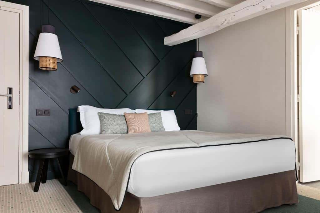Quarto do Hotel Bastille Speria, um dos hotéis 3 estrelas em Paris. Uma cama de casal está no centro do quarto e tem mesinhas de cabeceira e abajures dos dois lados.