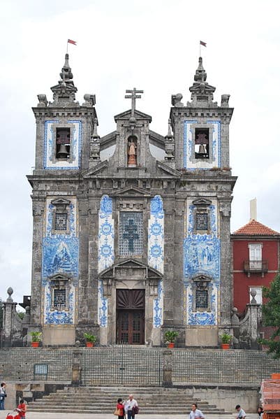 Imagem da Igreja de Santo Ildefonso durante o dia com a catedral no centro com arquitetura barroca e na fachada decoração com azulejos.