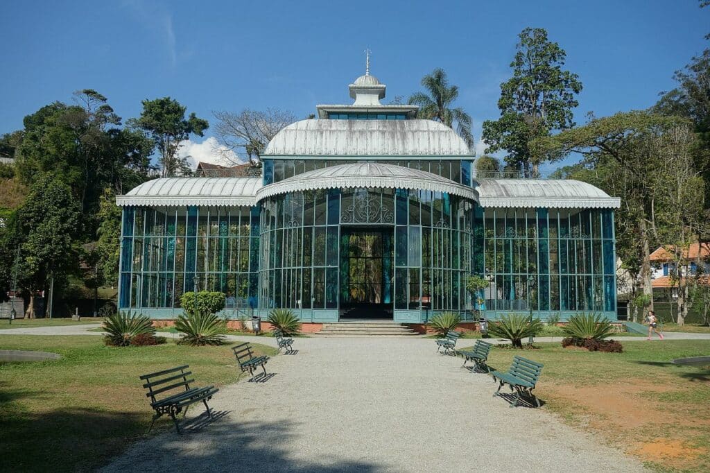 Palácio de Cristal, uma estrutura de vidro no centro de um parque em Petrópolis