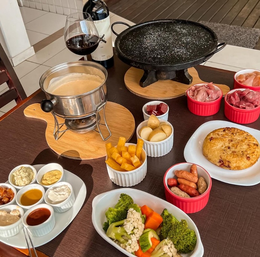 Rodízio de fondue no Princesa Isabel Gourmet com queijos, carnes, legumes e diversos molhos, além da panela com queijo derretido