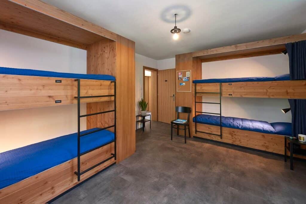 Quarto compartilhado do Chalet Turbina com uma cama beliche do lado direito e do lado esquerdo outra cama beliche.