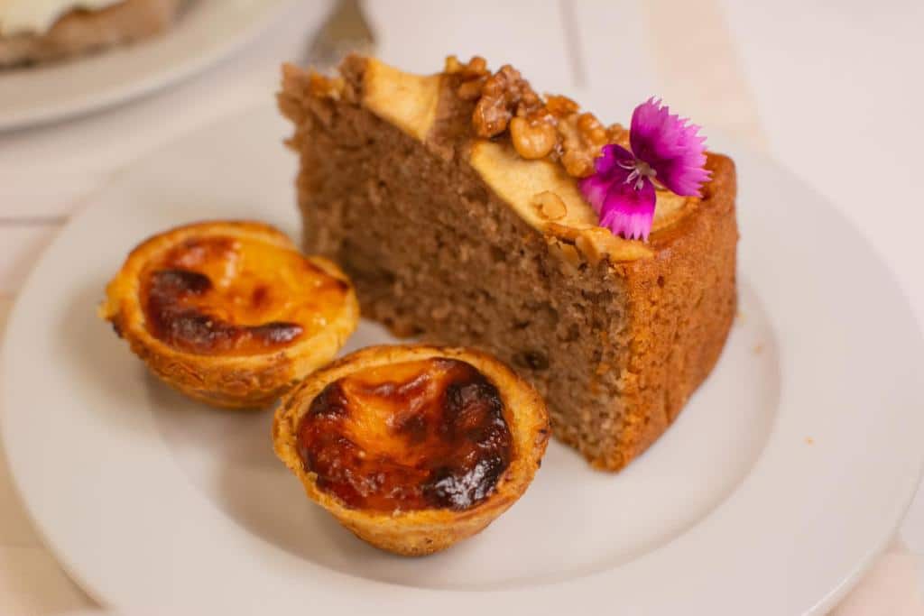 Itens que fazem parte do café da manhã servido no VIP Executive Arts Hotel, há um pedaço de bolo com castanhas e dois pastéis de Belém.