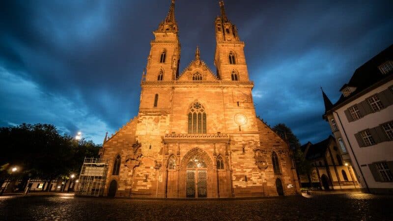 Imagem da frente da Catedral de Basileia no final do dia com a igreja no centro. Representa o que fazer em Basel.