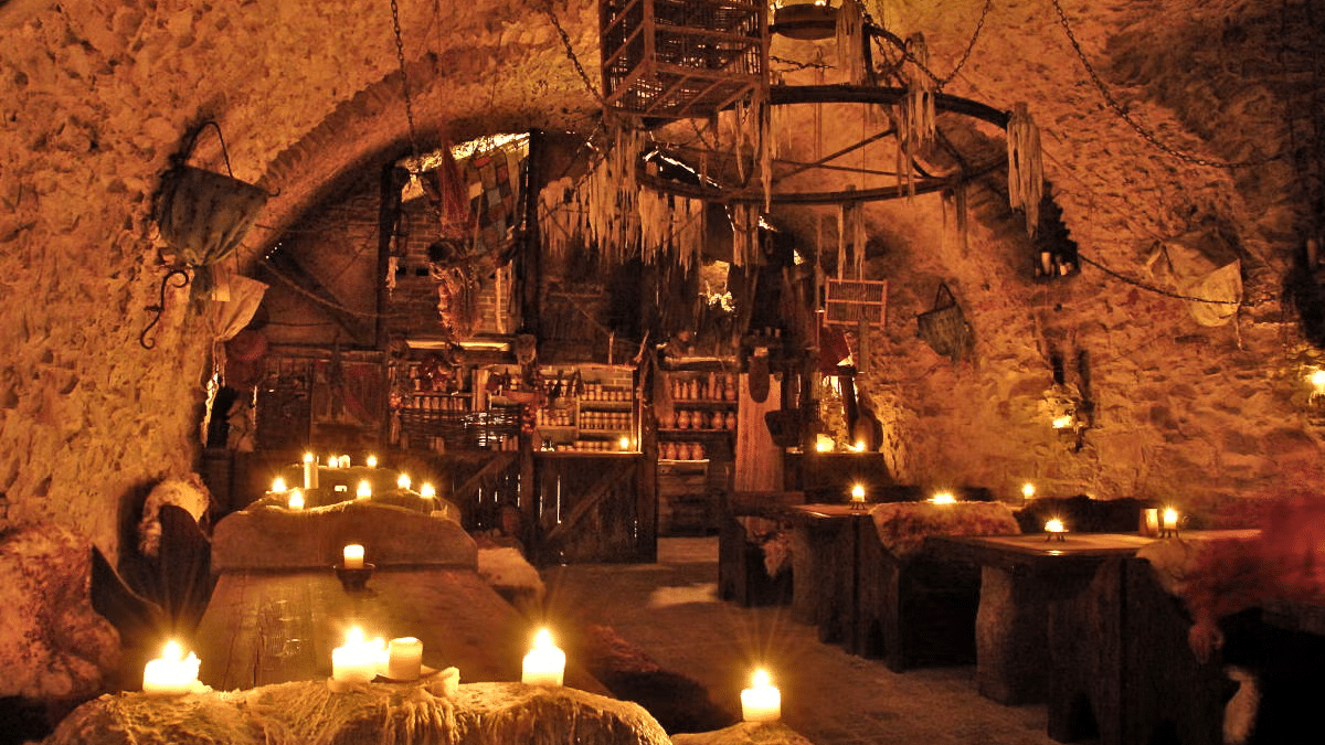 Imagem do interior de um restaurantes temáticos estilo medieval com mesas e bancos de madeira.