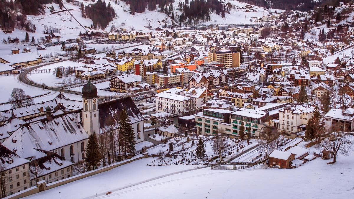 Imagem de cima de uma cidade durante o dia com edifícios cobertos de neve.