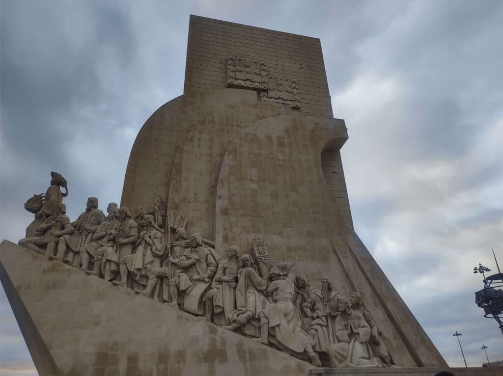 Imagem do Padrão dos Descobrimentos durante o dia com a escultura do lado direito. Representa o que fazer em Lisboa.