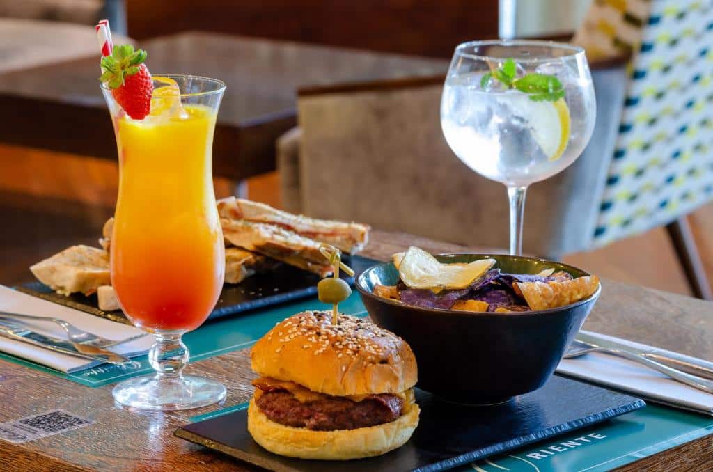 Refeição servida no Olissippo Oriente com um lanche de hambúrguer, fritas, lanches com presunto e queijo, e dois drinques, para representar hotéis perto do Parque das Nações em Lisboa.