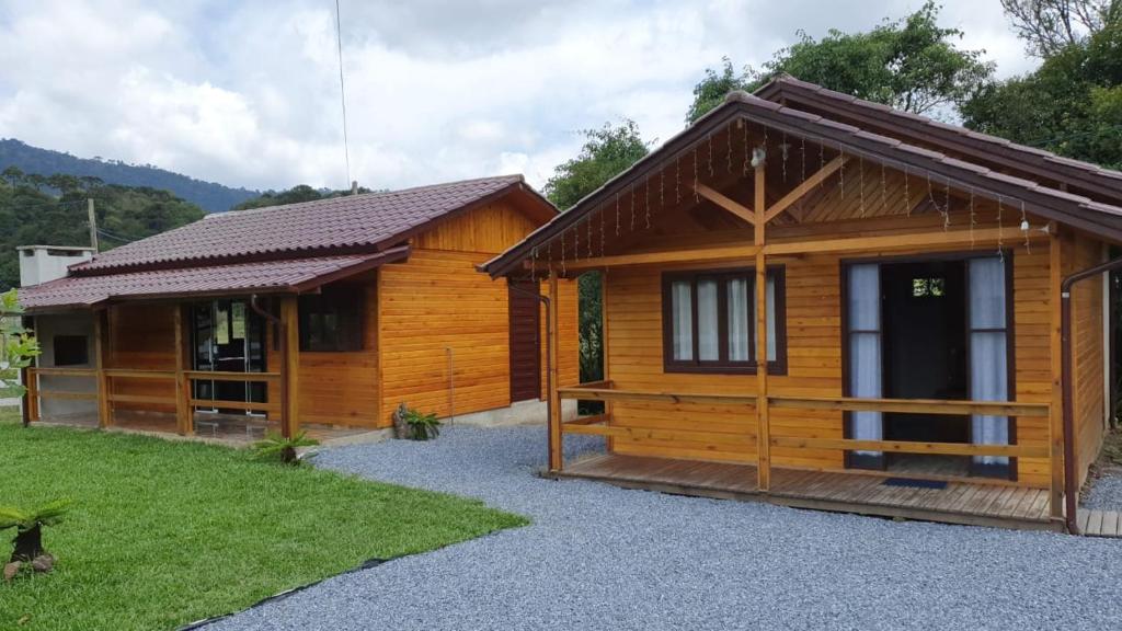 Fachada dos chalés na Pousada Rio Canoa em madeira, janelas e portas de vidro fosco com cortinas.