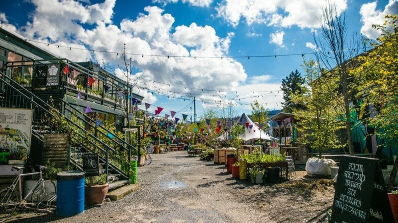 Imagem durante o dia do Frau Gerolds Garten em cada lado da imagem área verde e alguns estabelecimentos.
