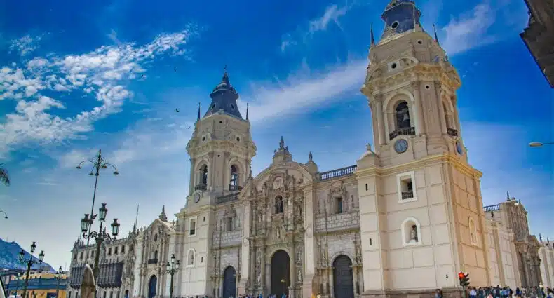 Imagem de um difício de concreto bege sob céu azul e nuvens brancas durante o dia em Lima. Representa o que fazer em Lima.