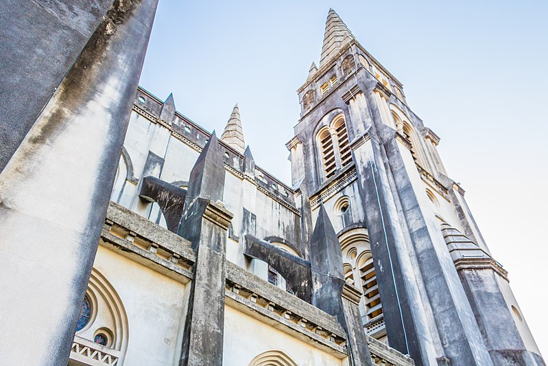 Foto da Catedral Metropolitana de Fortaleza, em um ângulo de baixo para cima, focando nas torres da construção. O céu está claro e sem nuvens.