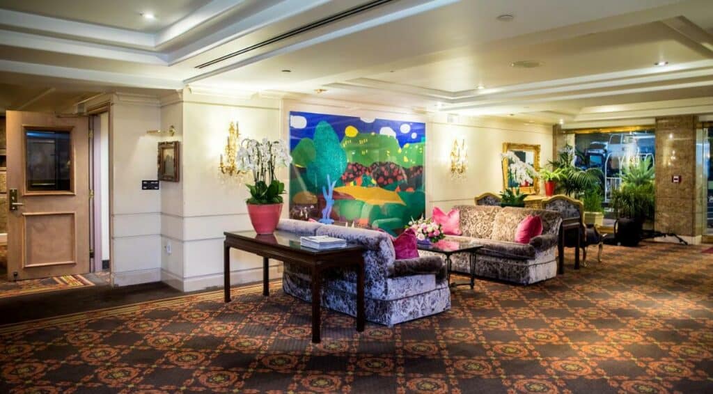 Recepção do New Seoul Hotel. Sofás, mesa de centro e vasos com flores.