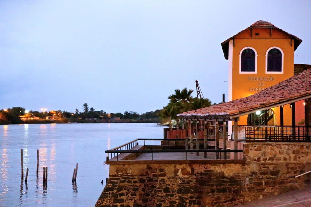 Imagem do Porto das Barcas no final do dia com o porto do lado direito e do lado esquerdo o rio. Representa o que fazer no Delta do Parnaíba.