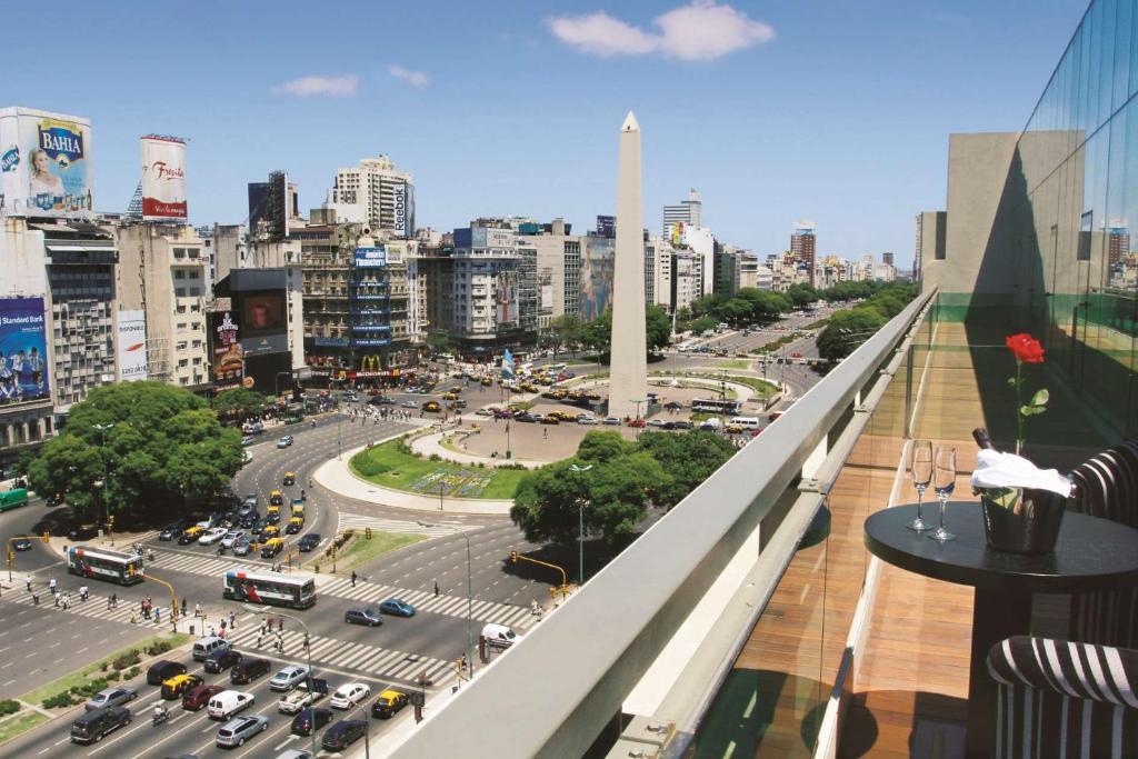 Vista do NH Buenos Aires Tango um dos hotéis no centro de Buenos Aires que dá direto para o Obelisco, sendo possível observar ainda a praça abaixo, prédios ao fundo e mais carros passando nas ruas.