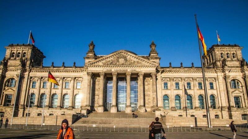 Imagem da frente da Casa do Parlamento durante o dia com pátio a frente e edifício ao fundo. Representa o que fazer em Berlim.