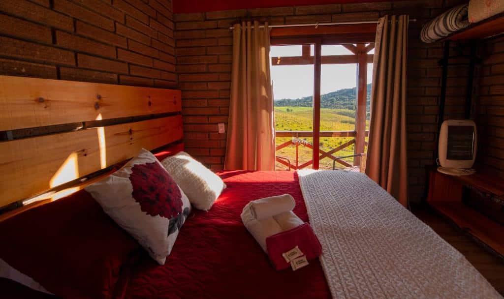 Quarto do Chalés Corucacas. Uma cama de casal do lado esquerdo, no fundo a porta da varanda.