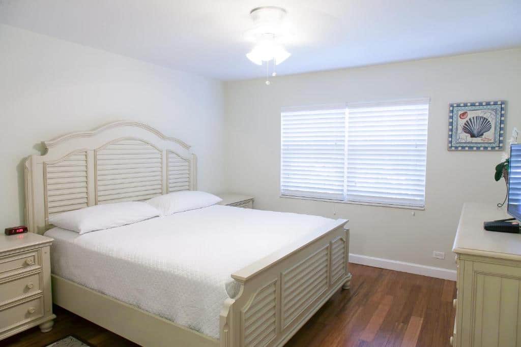 Quarto do Dolphin Cove que mostra do lado esquerdo uma cama de casal e de cada lado da cama uma mesa de cabeceira. De frente para a cama tem uma cômoda com uma tv e do lado esquerdo da cama tem uma janela.