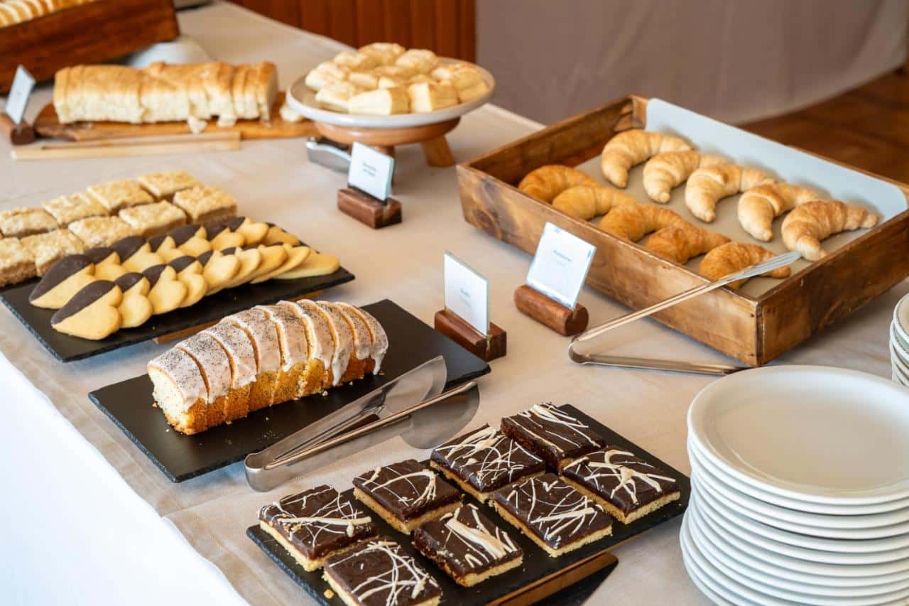 Mesa com uma parte do café da manhã do Gran Hotel Panamericano, com pães e doces. Imagem para ilustrar post sobre onde ficar em Bariloche.