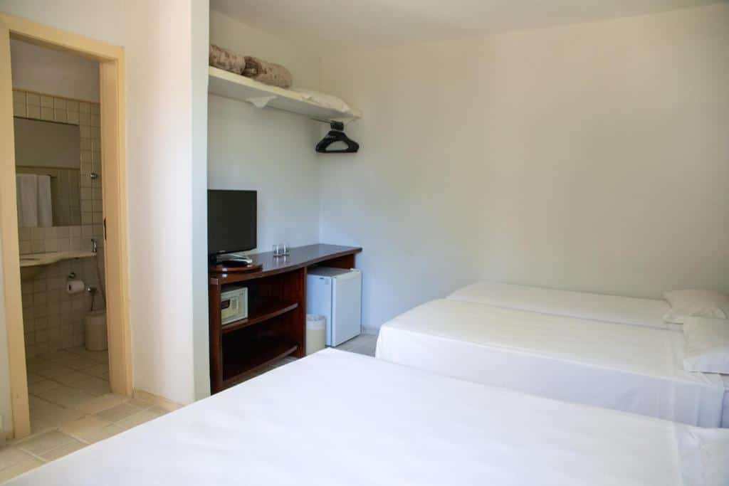 Quarto do Eco Chalés com camas de solteiro e decoração minimalista, equipado com TV e frigobar. Um dos hotéis no Rio Quente Resorts.