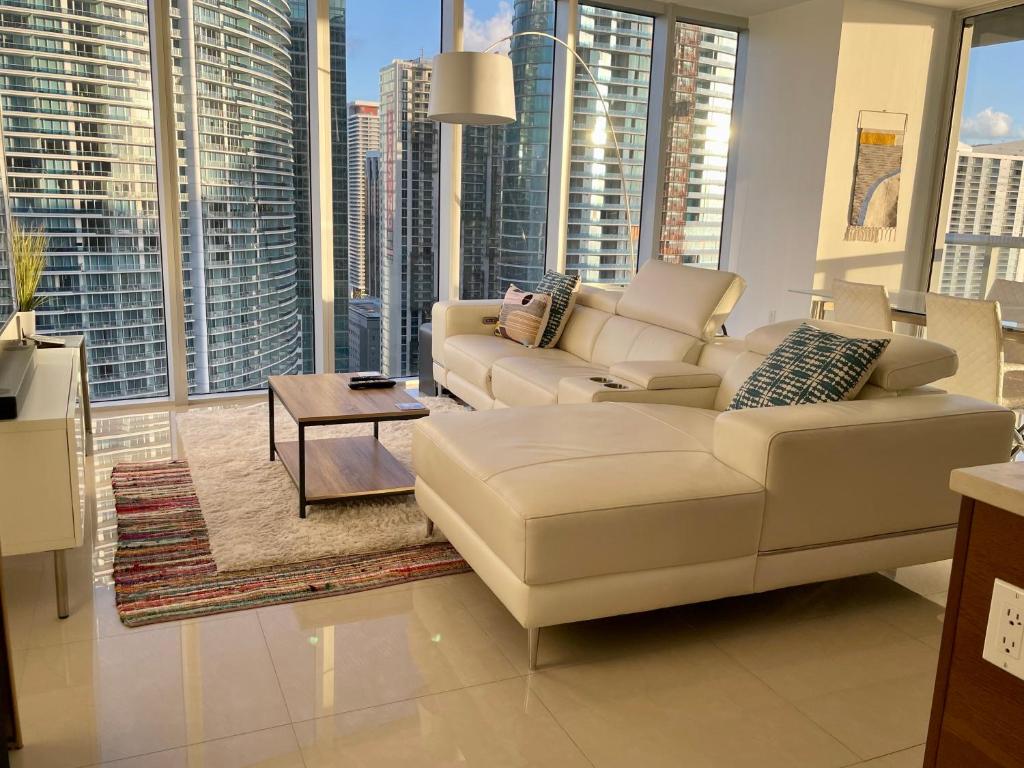 Sala de estar do IconBrickell Tower 3 W Residences com sofá do lado direito da imagem no centro uma mesa quadrada e uma cômoda a frente.